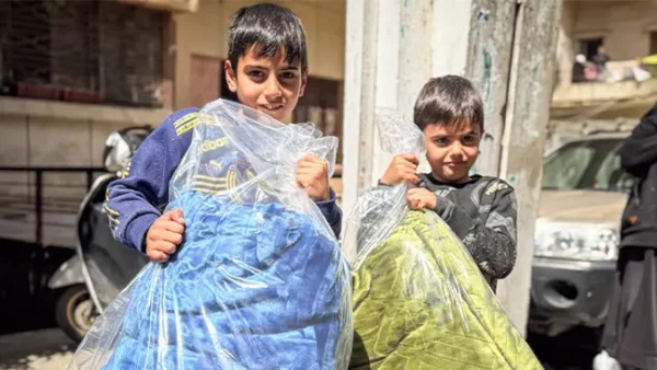 Des enfants récupèrent des couvertures distribuées par Islamic Relief dans le cadre de la réponse d’urgence au Liban, en 2026.